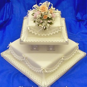 Charmaine - Square Ivory Wedding Cake with delicate coloured sugar flowers, lace effect frills & satin bows
